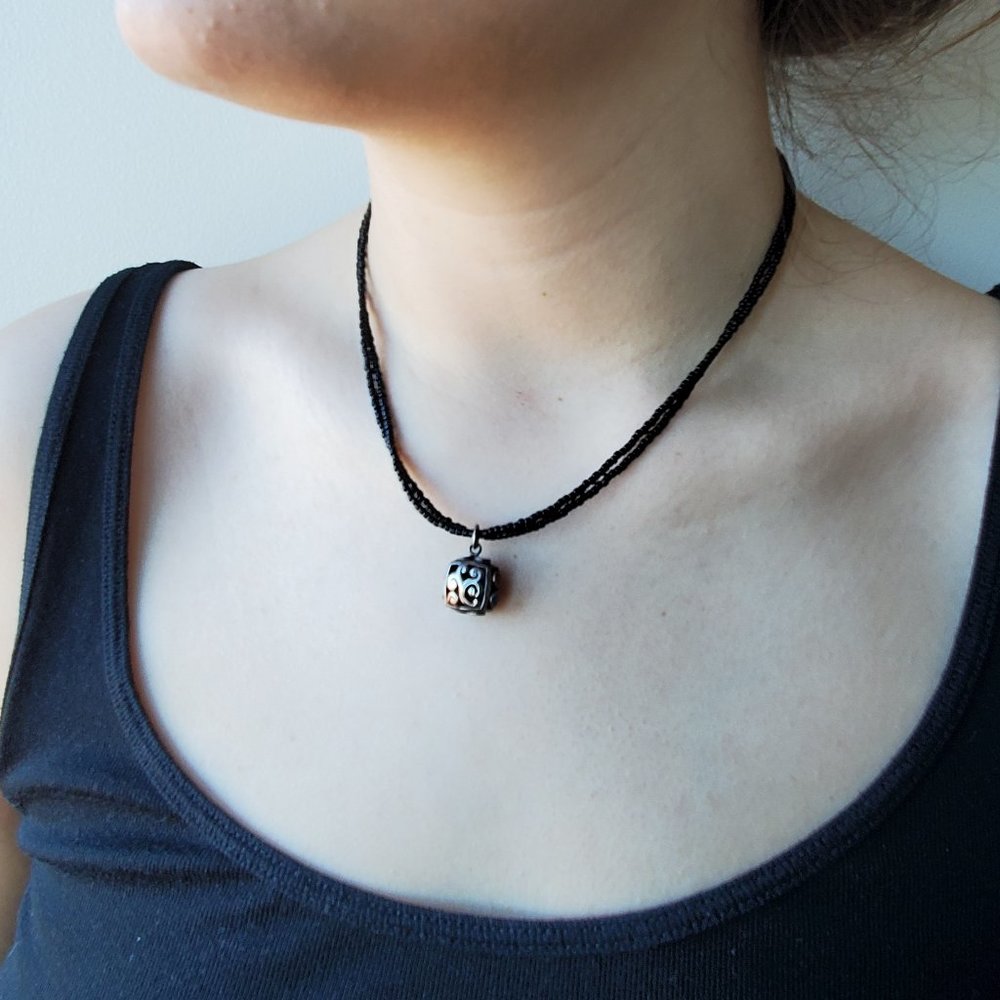Black bead necklace with silver charm